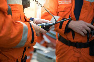 Close up of a worker holding a walkie talkie