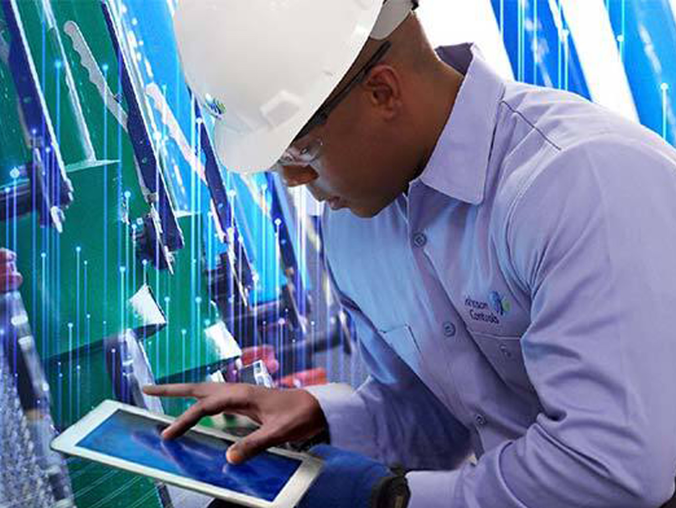 A Johnson Controls worker in a safety helmet kneeling and working on a tablet with graphics of transmission nodes in the background