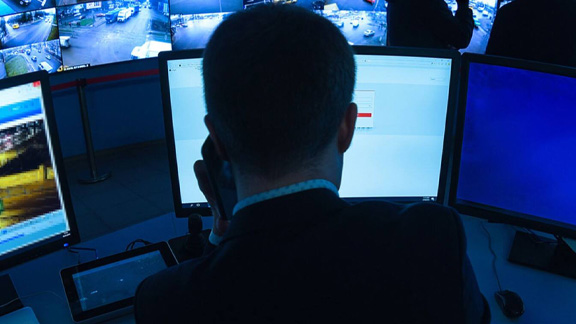 Close up of a security personnel watching the CCTV footages in the control room
